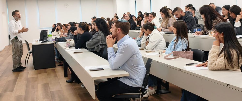 A lecturer addressing a full hall of students