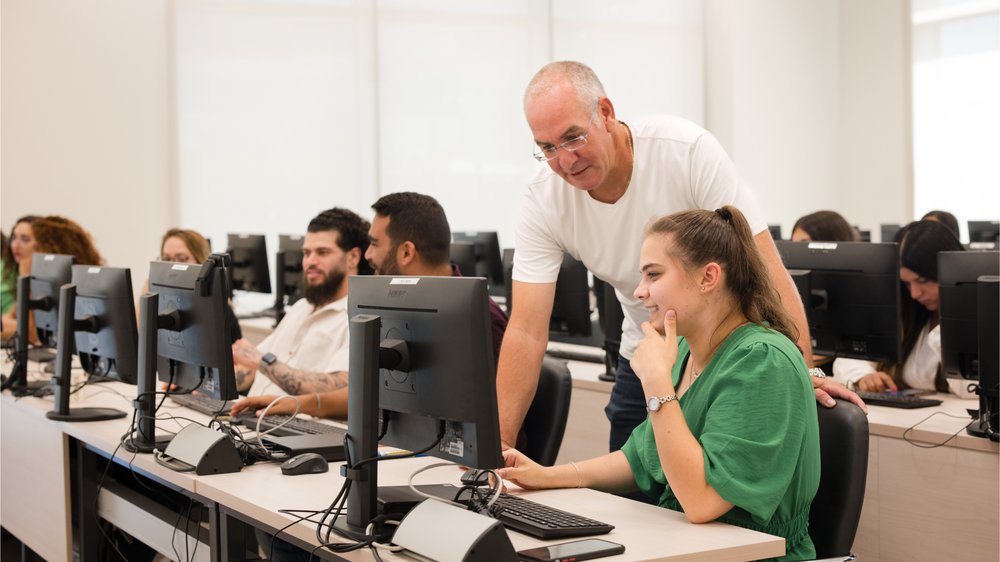 A lecturer helping a student at a computer in a Peres Academic Center lab