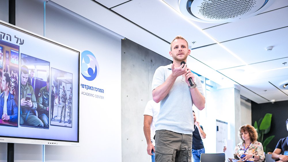 A student speaking to an audience at the Peres Academic Center